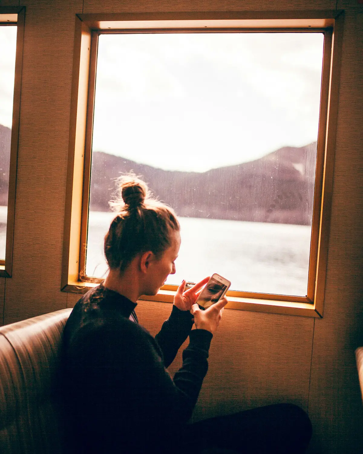Someone checking their day on their phone by a window